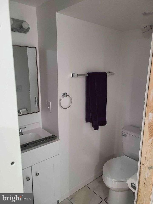 bathroom featuring toilet, tile patterned flooring, vanity, and baseboards