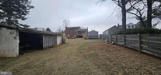 view of yard featuring a pole building, fence, and an outdoor structure