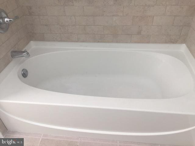 bathroom featuring a relaxing tiled tub