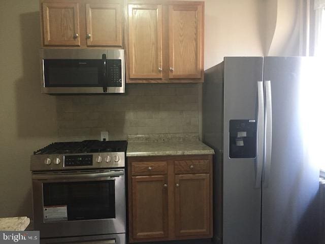 kitchen featuring appliances with stainless steel finishes and decorative backsplash