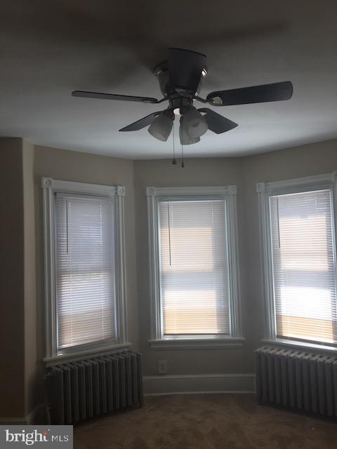 interior space with radiator and dark colored carpet