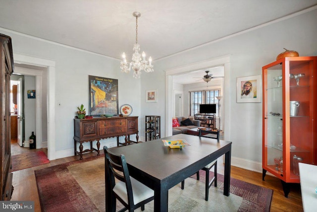 dining room featuring dark wood-type flooring, ornamental molding, and ceiling fan