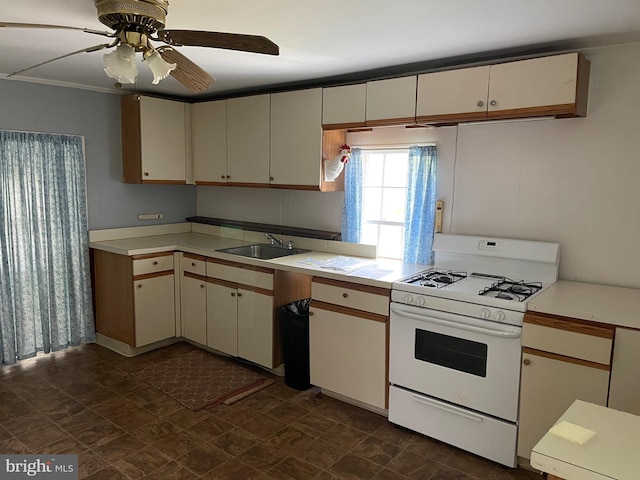 10037 Main St, Berlin, MD 21811 - kitchen featuring white gas stove, a sink, light countertops, a ceiling fan, and crown molding