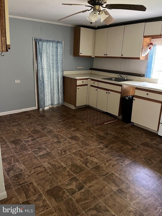 10037 Main St, Berlin, MD 21811 - kitchen featuring a sink, a ceiling fan, light countertops, crown molding, and cream cabinetry