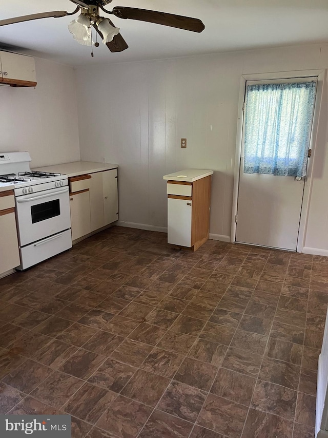 10037 Main St, Berlin, MD 21811 - kitchen with white range with gas stovetop, ceiling fan, light countertops, and white cabinetry