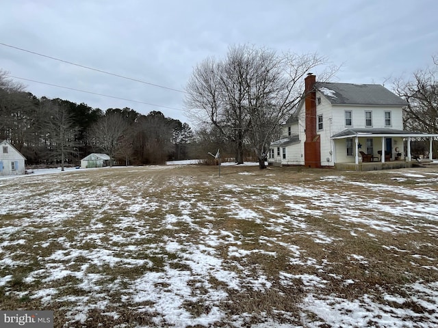 yard covered in snow featuring covered porch