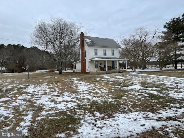 snow covered property featuring covered porch