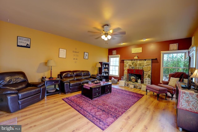 living room featuring ceiling fan, a fireplace, and hardwood / wood-style floors