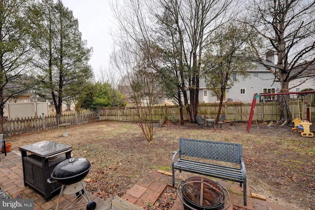 view of yard with a patio, a playground, and an outdoor fire pit