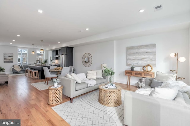 living room featuring visible vents, wood finished floors, and recessed lighting