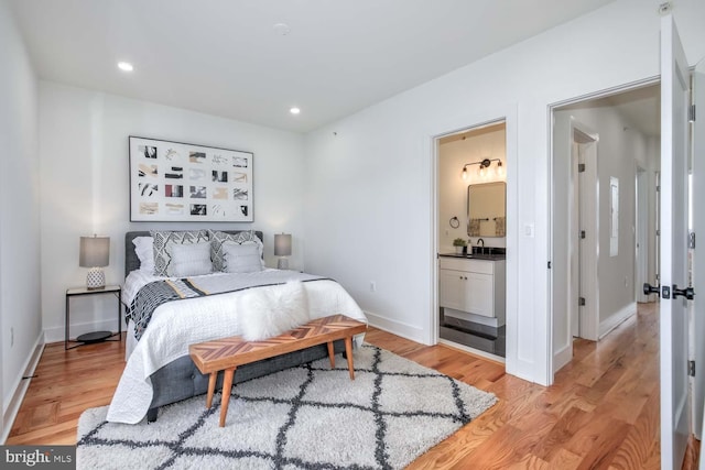 bedroom featuring baseboards, ensuite bathroom, light wood-style flooring, and recessed lighting