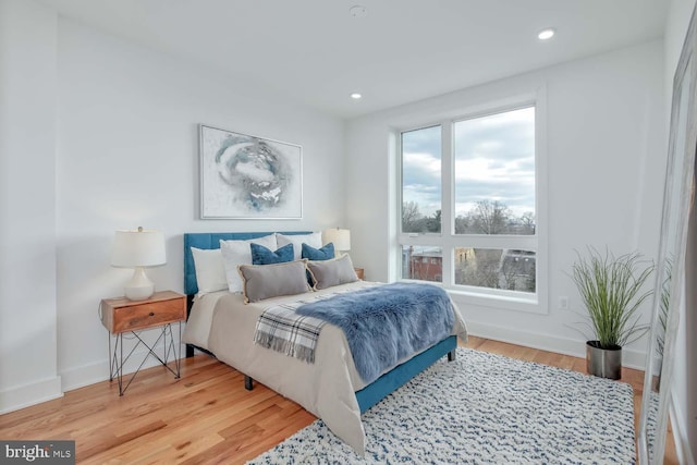 bedroom with baseboards, wood finished floors, and recessed lighting