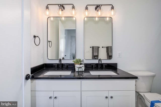 bathroom featuring a sink, toilet, and double vanity