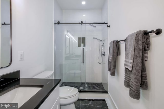 bathroom featuring baseboards, toilet, marble finish floor, vanity, and a shower stall