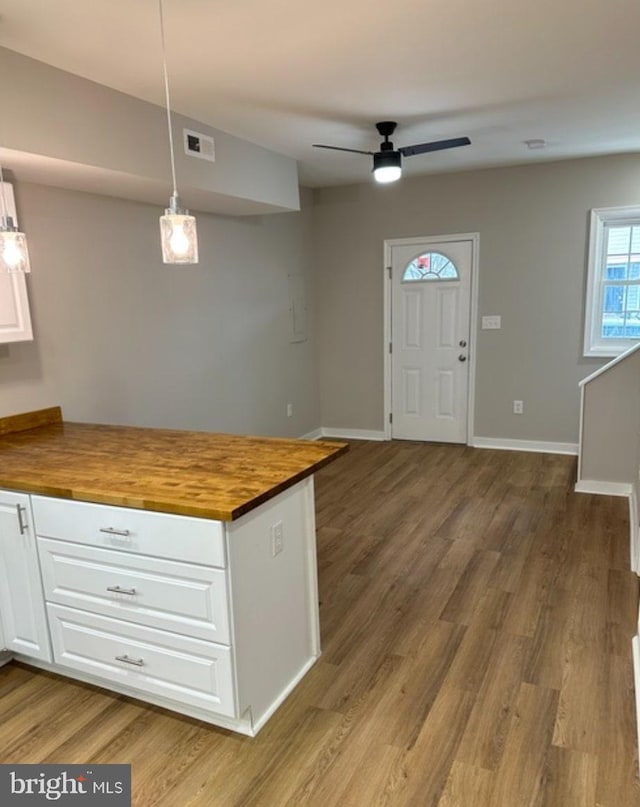 kitchen with hardwood / wood-style flooring, ceiling fan, butcher block counters, white cabinetry, and decorative light fixtures