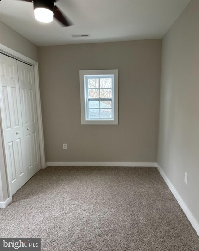 unfurnished bedroom with a closet, ceiling fan, and carpet flooring