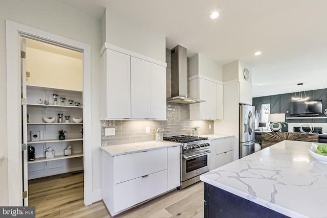 kitchen with white cabinetry, wall chimney exhaust hood, and appliances with stainless steel finishes