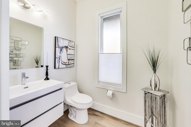 bathroom featuring vanity, toilet, and hardwood / wood-style floors