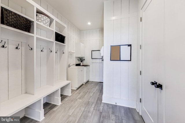 mudroom with sink and light hardwood / wood-style floors