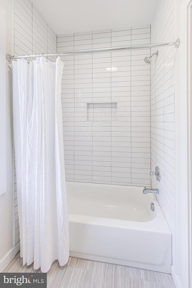 bathroom with wood-type flooring and shower / bath combo with shower curtain