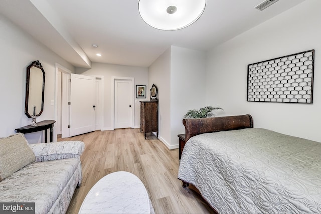 bedroom featuring multiple closets and light hardwood / wood-style floors