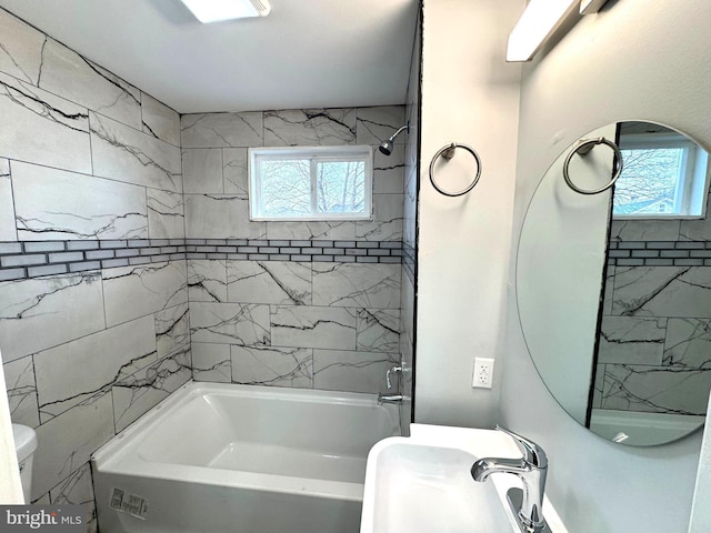 bathroom featuring tiled shower / bath and toilet