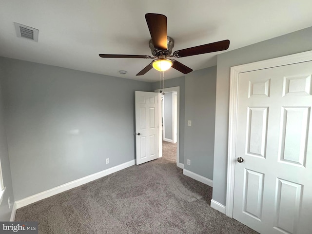 unfurnished bedroom featuring ceiling fan and dark carpet