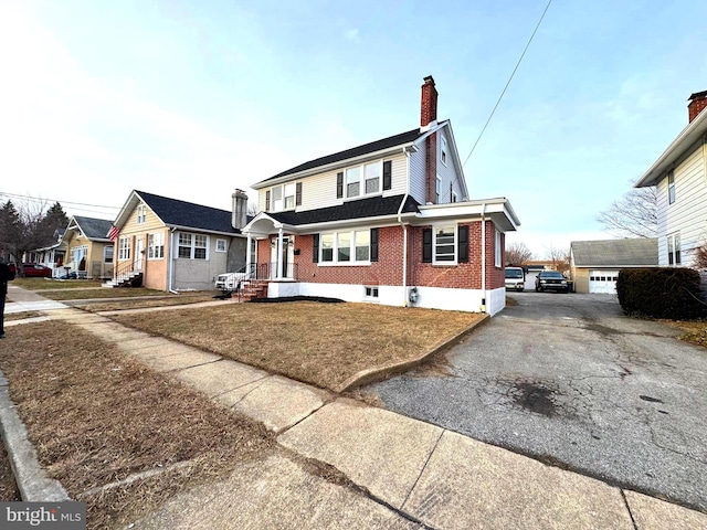 view of front of home featuring a garage, an outbuilding, and a front yard