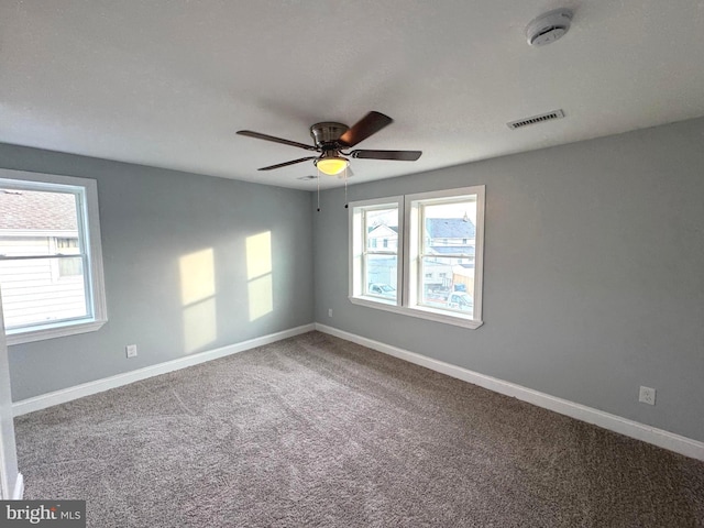 carpeted spare room featuring ceiling fan