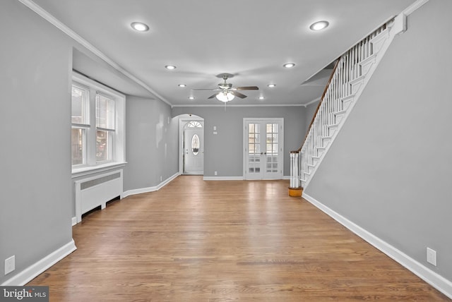 entryway featuring french doors, ornamental molding, radiator, and light wood-type flooring