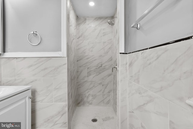 bathroom with vanity, tile walls, and a tile shower