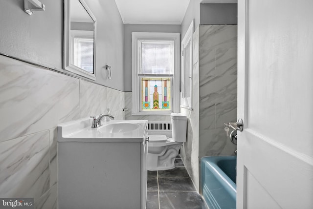 bathroom featuring vanity, a tub, tile walls, and toilet