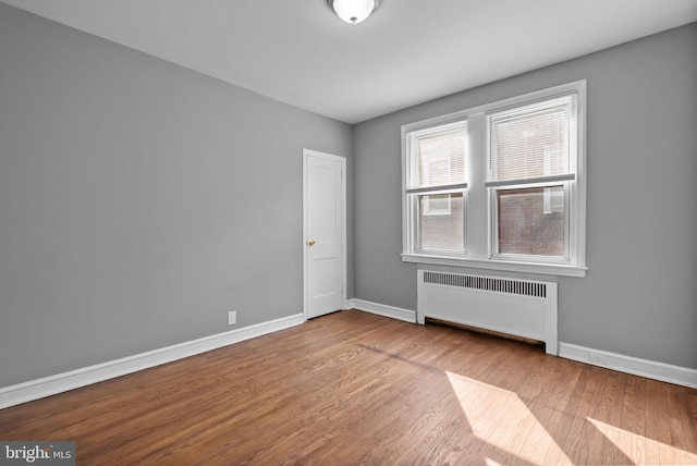 empty room with radiator and light wood-type flooring