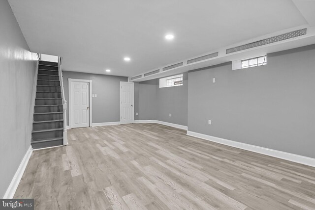 basement with light hardwood / wood-style flooring