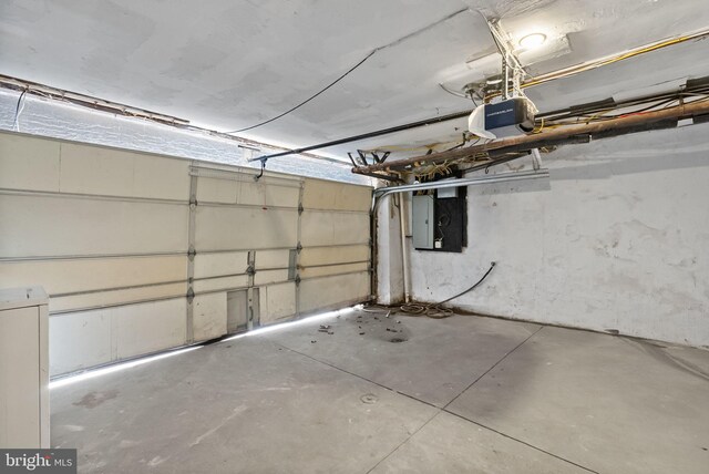 garage with a garage door opener and electric panel