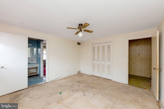 unfurnished bedroom with ensuite bathroom, ceiling fan, and a closet