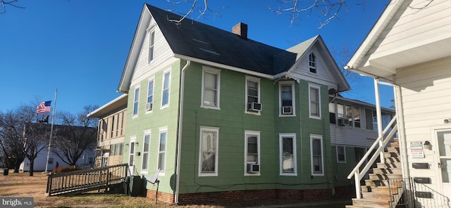 view of side of property featuring crawl space, roof with shingles, and a chimney