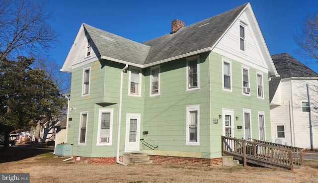 view of front of home with a shingled roof and a chimney