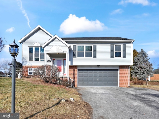 split foyer home featuring a garage and a front lawn