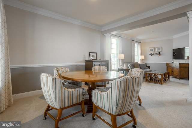 dining area with decorative columns, ornamental molding, and light colored carpet