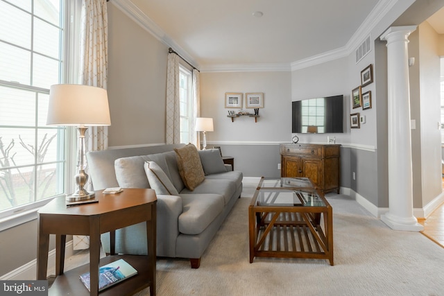 living room featuring crown molding, decorative columns, light carpet, and a wealth of natural light