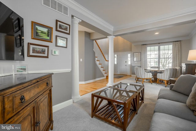 living room featuring light carpet, ornamental molding, and decorative columns