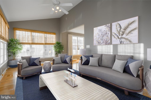 living room with ceiling fan, high vaulted ceiling, and light hardwood / wood-style floors