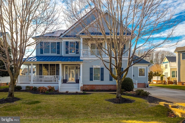 view of front of property featuring a front lawn, solar panels, and a porch