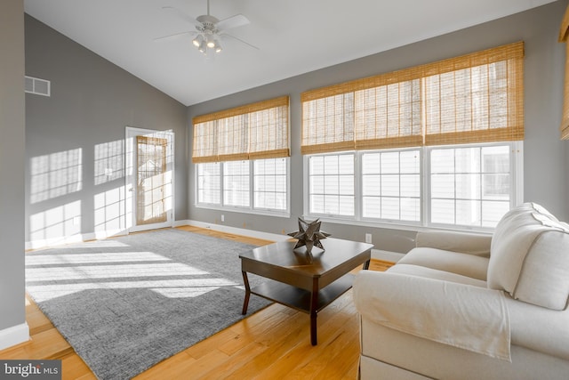 living room featuring vaulted ceiling, ceiling fan, and light wood-type flooring