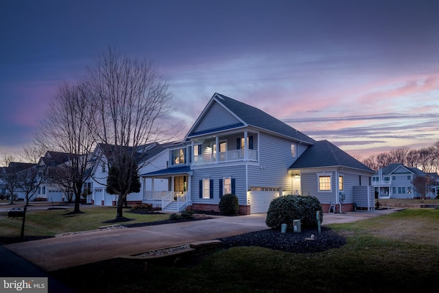 view of front of home with a balcony, a garage, and a lawn