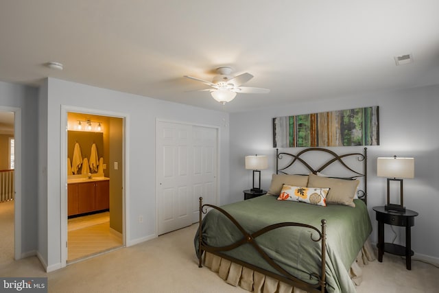 carpeted bedroom featuring ceiling fan, ensuite bathroom, and a closet