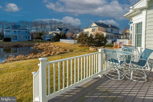 deck with a water view and a yard