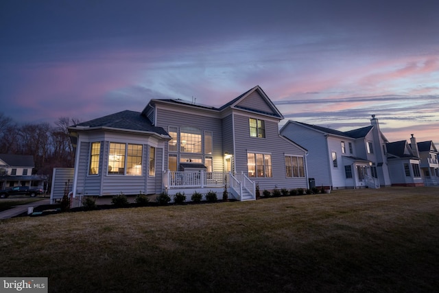 view of front of property featuring a yard and a deck