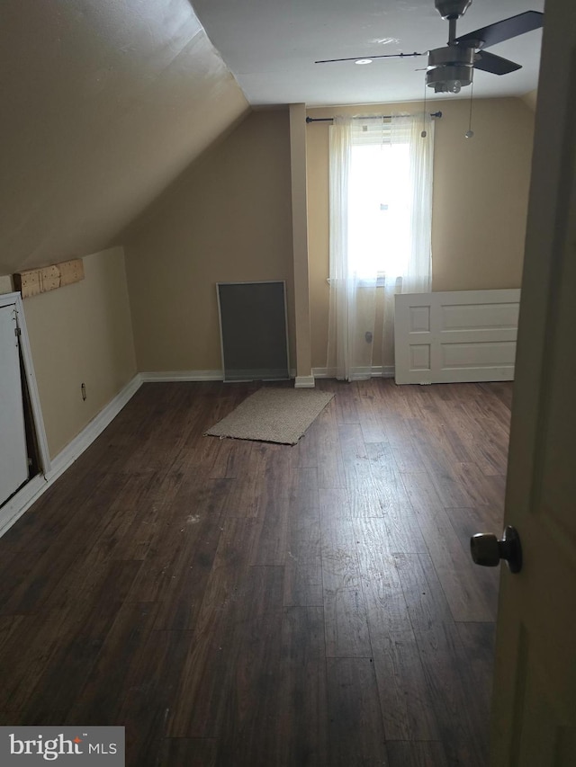 additional living space with vaulted ceiling, dark hardwood / wood-style floors, and ceiling fan